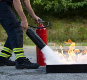 A worker testing a fire extinguisher