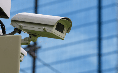 Outdoor security surveillance camera mounted on a building, representing Summit Companies' monitoring services