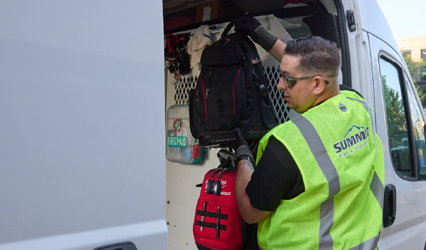 A technician retrieving supplies from a Summit service van, for field work on a government account